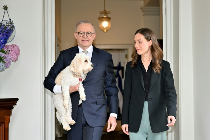 Australian Prime Minister Anthony Albanese carrying his dog Toto welcomes Finland’s Prime Minister Sanna Marin at Kirribilli House in Sydney on December 2, 2022.