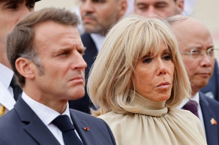 Grim day: France's President Emmanuel Macron and his wife Brigitte Macron at a wreath-laying ceremony in Hanoi Monday