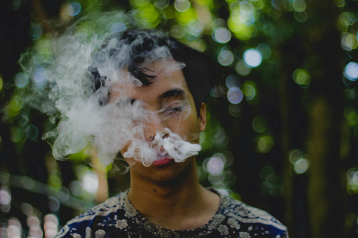 man blowing white smoke
