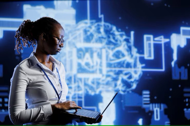 Woman browsing on PC with AI symbol behind.