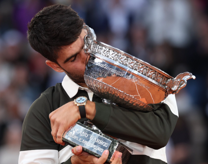 Carlo Alcaraz kissing his French Open trophy