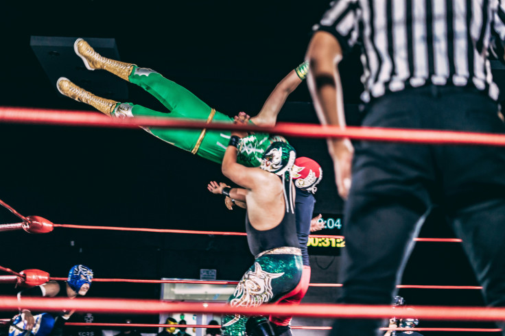A person holding another man in a ring