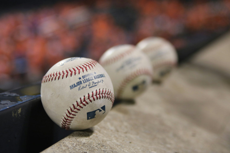 Three white baseballs on grey textile