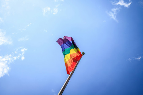 Multi colored flag under a blue sky during the daytime