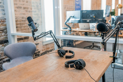 Two black headphones on brown wooden table