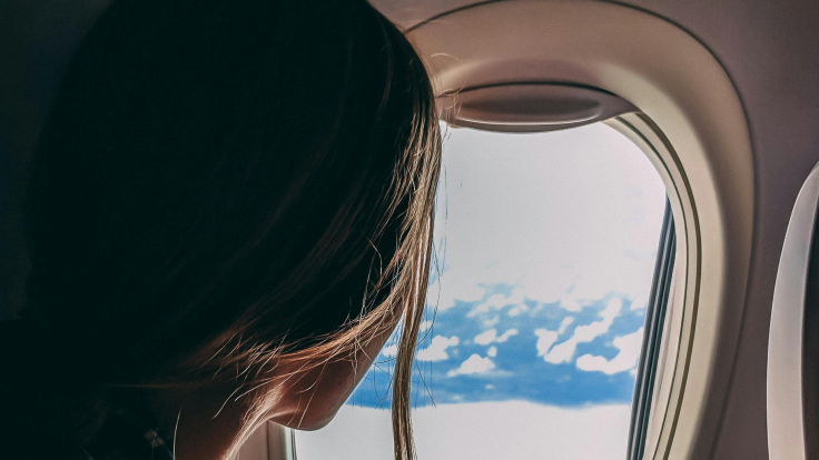 Woman looking out of plane window