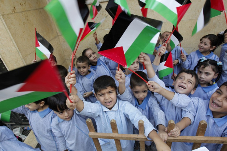 Palestinian children wave their national flags at the Palestinian Shatila refugee camp in Beirut