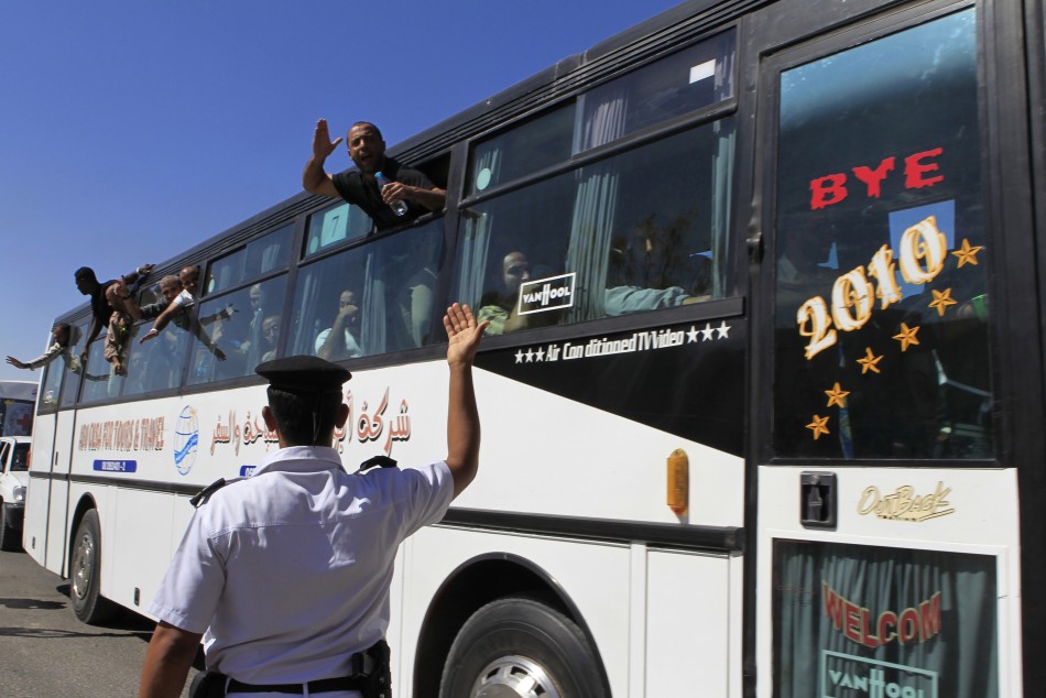 Released Palestinian prisoners wave from a bus as they make their way through the Rafah border crossing between Egypt and Gaza