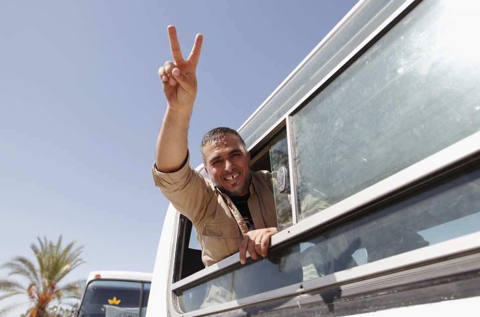 Palestinian prisoner, released by Israel in exchange for Israeli soldier Shalit, gestures from a bus as he makes his way through the Rafah border crossing between Egypt and Gaza