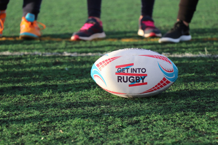 White, blue and red football on green grass