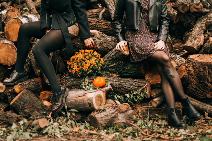 Women Sitting on Pile of Tree Logs