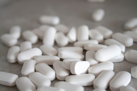 White medication pills on brown surface