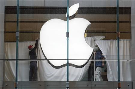 Staff members hang privacy drapes in the window of the Apple store in Boston