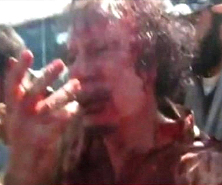 Frame grab of former Libyan leader Muammar Gaddafi, covered in blood, being pushed to the ground by NTC fighters in Sirt