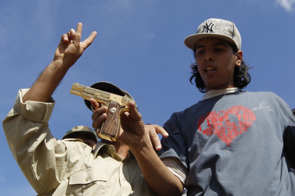 Anti-Gaddafi fighters show the media what they claim was the golden pistol of Muammar Gaddafi, near Sirte
