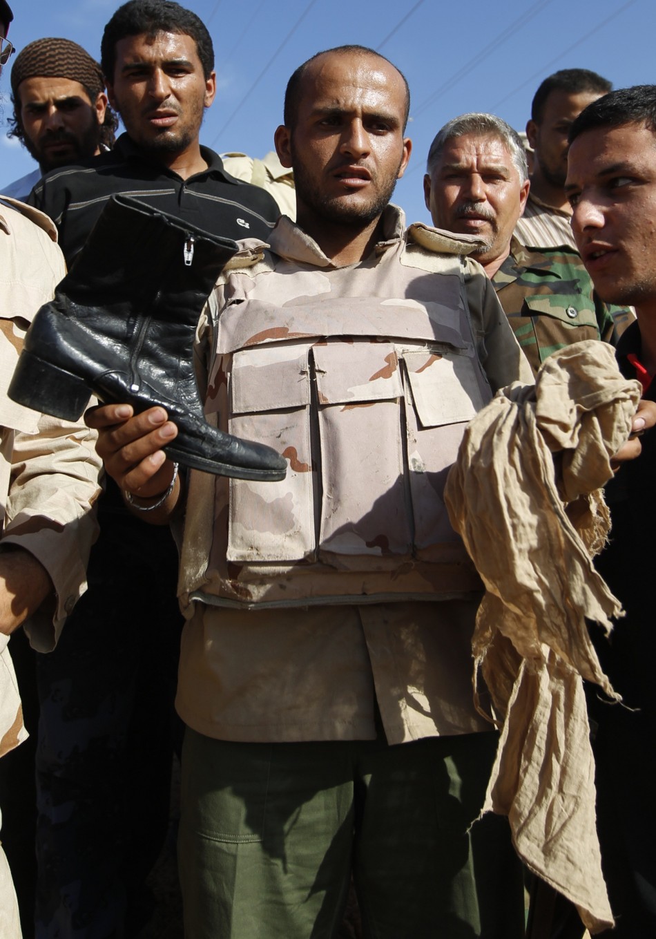 Anti-Gaddafi fighter shows the media clothes of Muammar Gaddafi near Sirte