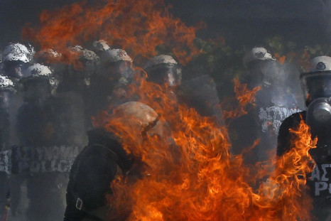 A Greek police officer is set partly on fire by an exploding petrol bomb, thrown by anti-austerity protesters, outside the parliament during clashes in Athens