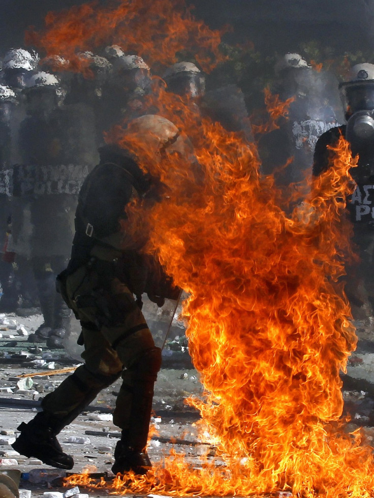 A Greek police officer is set partly on fire by an exploding petrol bomb, thrown by anti-austerity protesters, outside the parliament during clashes in Athens