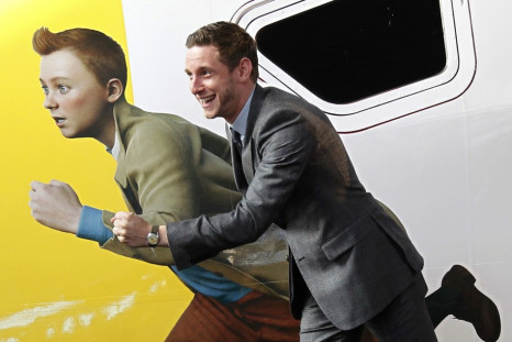Actor Jamie Bell imitates a figure of Tintin, painted on a Thalys high-speed train, in Brussels