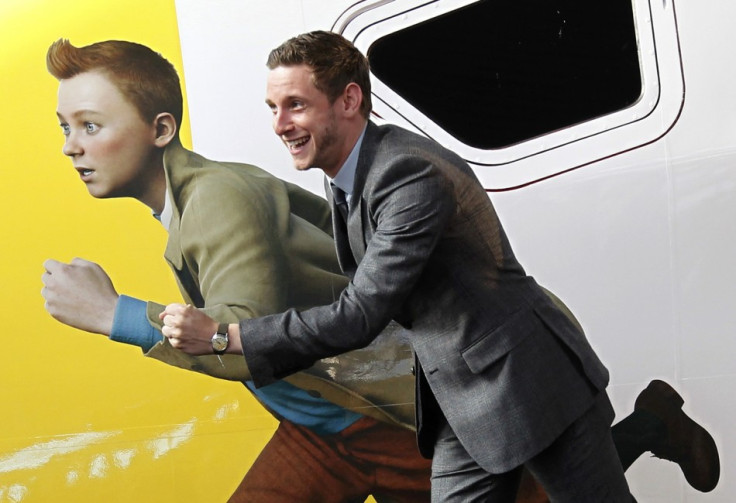 Actor Jamie Bell imitates a figure of Tintin, painted on a Thalys high-speed train, in Brussels