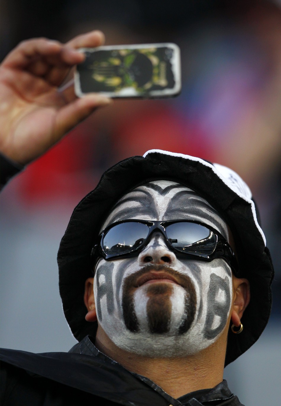 A New Zealand All Blacks039 fan takes a picture with his mobile phone before their Rugby World Cup final match against France at Eden Park in Auckland.