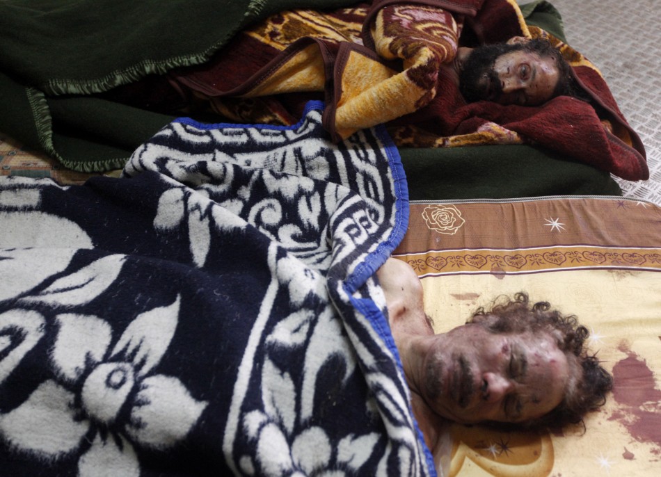 Dead bodies of Gaddafi and his son are displayed inside a metal storage freezer in Misrata