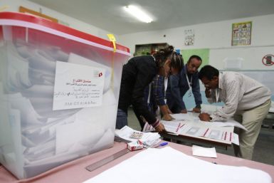 Officials collect votes from ballot boxes after the polls closed in a polling station in Tunis