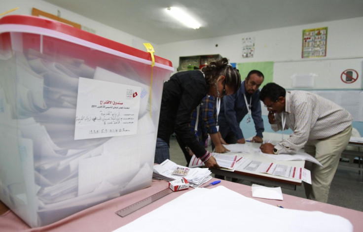 Officials collect votes from ballot boxes after the polls closed in a polling station in Tunis