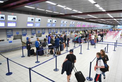 Airport passengers fall in line at check-in counters