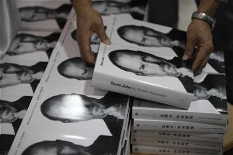 Man holds copy of authorized biography titled "Steve Jobs" near copies of the book officially translated into Chinese at a bookstore in Shanghai
