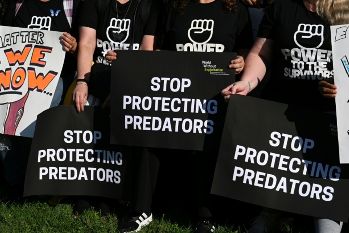 Demonstrators' signs at a rally supporting Epstein victims in 2025