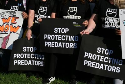 Demonstrators' signs at a rally supporting Epstein victims in 2025