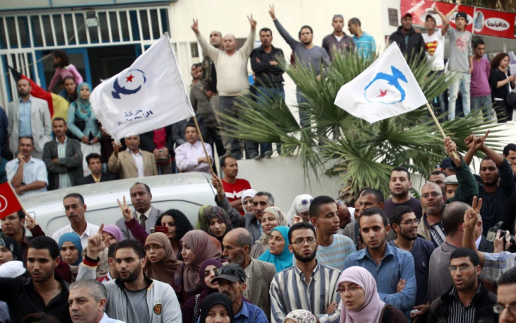 Supporters of the Islamist Ennahda movement hold party flags during Abdelhamid Jlazzi&#039;s speech outside the party&#039;s headquarters in Tunis