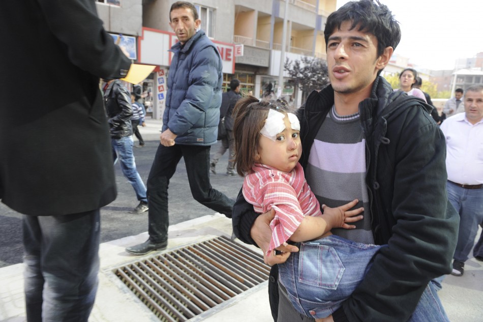 A man carries an injured girl after an earthquake in Tabanli village near the eastern Turkish city of Van on Monday.