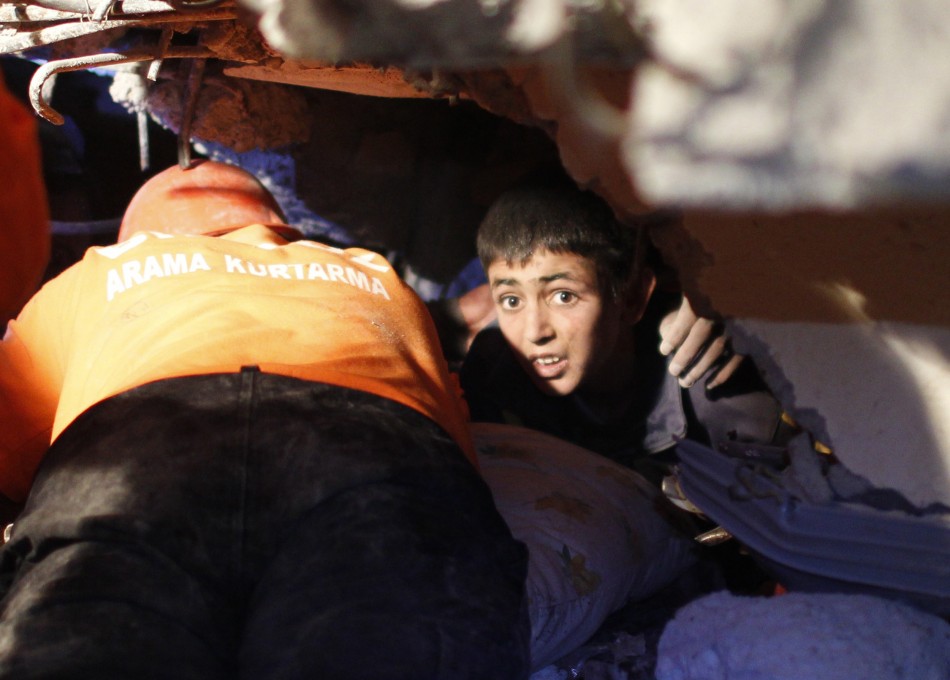 Yunus, a 13-year-old earthquake survivor, waits for to be rescued from under a collapsed building by rescue workers in Ercis, near the eastern Turkish city of Van on Monday.