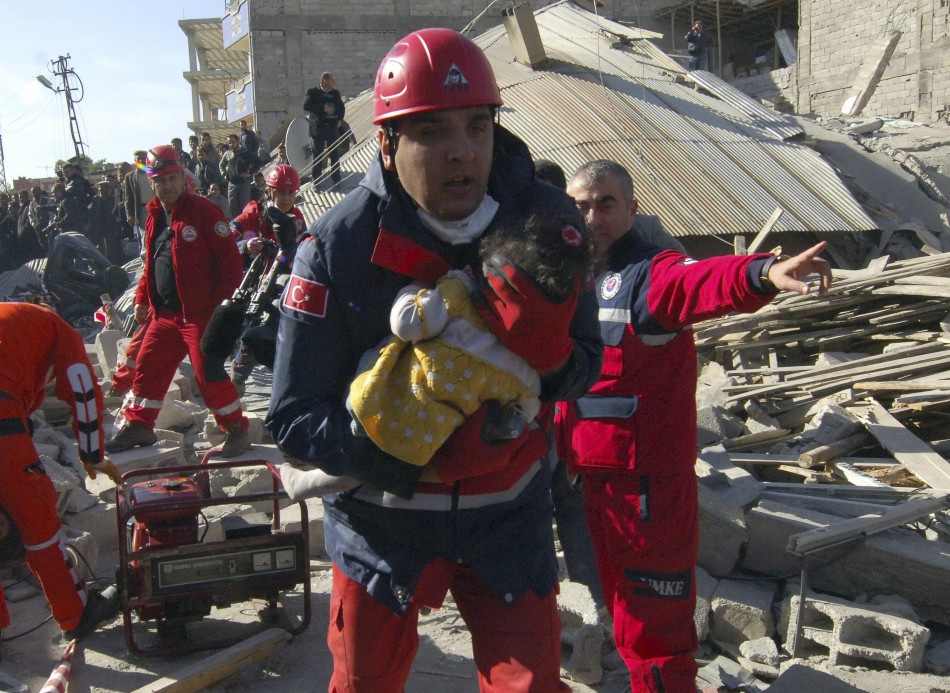 A rescue worker carrying a girl runs to an ambulance after his team found her alive in a collapsed building in Ercis, near the eastern Turkish city of Van on Monday.