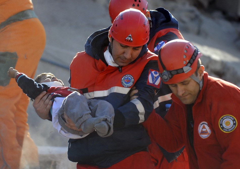 A rescue worker carries a boy to an ambulance after his team found him alive in a collapsed building in Ercis on Monday.