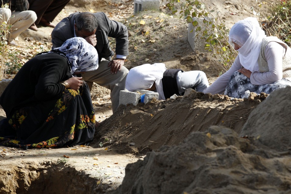 Survivors mourn over the grave of one of their relatives, killed during the earthquake, in Ercis on Monday.