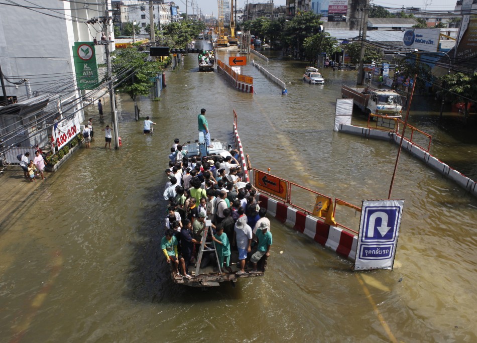 eople are transported on a truck through the flooded streets at Bang Phlat district in Bangkok