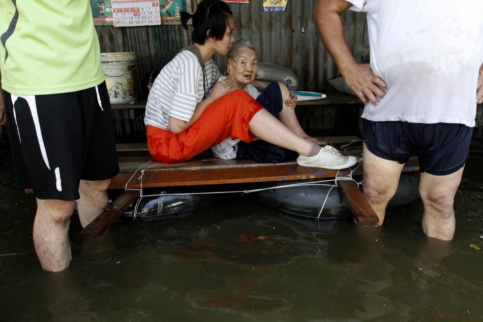 An elderly woman is evacuated as the floods advance into Bangkok