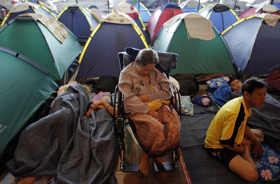 People evacuated from areas affected by floods pass time at a collective shelter at Don Mueang airport in Bangkok
