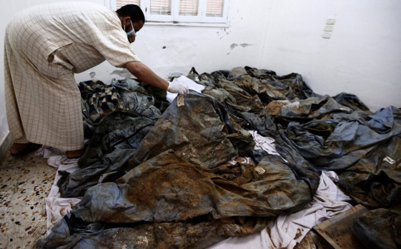 A man tries to identify his lost relatives among unearthed bodies suspected to have been killed by Gaddafi&#039;s forces in Khums