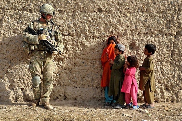 Corporal Calum Cooper Argyll and Sutherland Highlanders, 5th Battalion The Royal Regiment of Scotland, talks to local children while he carries out searches on compounds in Afghanistan. This picture, taken by Sgt Rupert Frere, won the Best Overall Image.