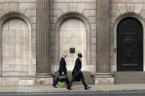 Two men walk past the Bank of England in the City of London
