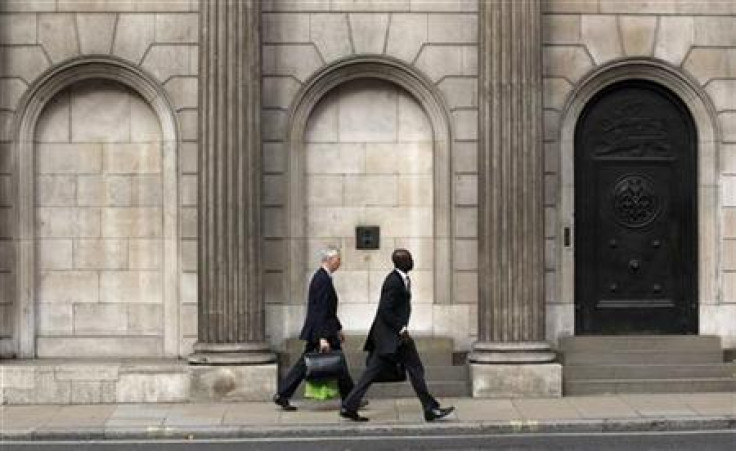 Two men walk past the Bank of England in the City of London