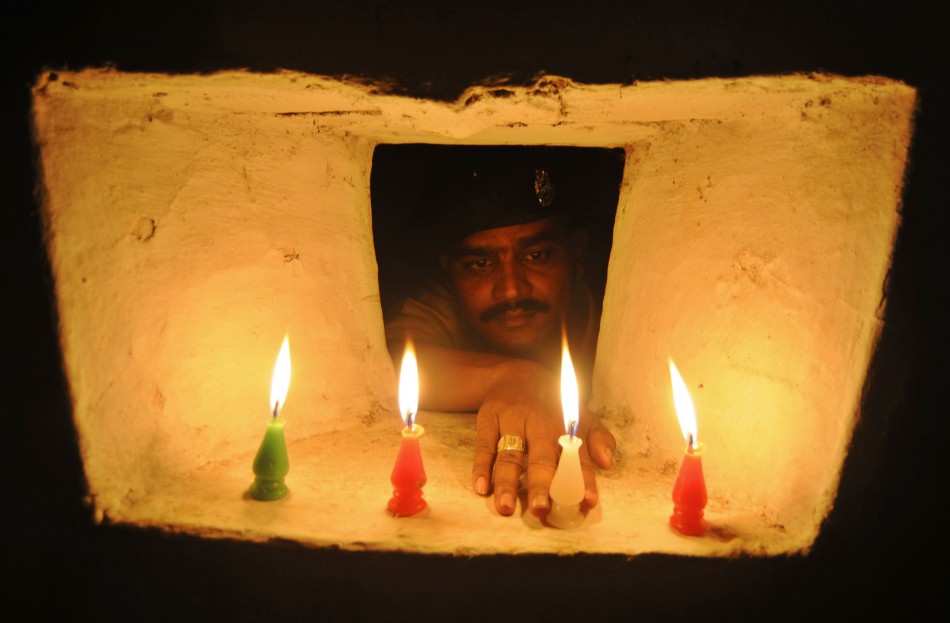 An Indian BSF soldier lights a candle inside a bunker on the occasion of the Hindu festival of Diwali at the India-Bangladesh border on the outskirts of Agartala