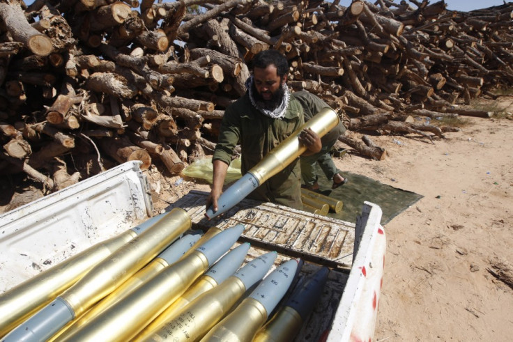 An anti-Gaddafi fighters loads tank shell on a pickup truck during a clashes with pro-Gaddafi forces in Sirte