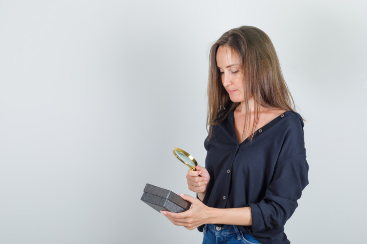 Woman inspecting using a magnifying glass