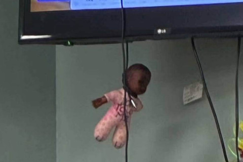 Black doll tied in a cord