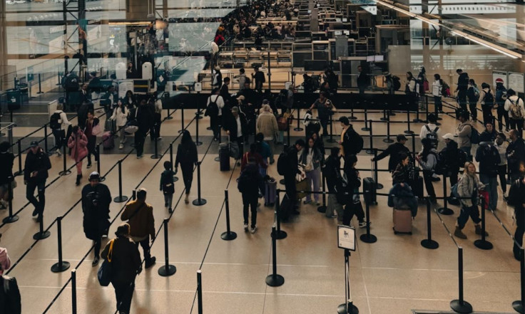Group Of People Walking Around Airport Terminal